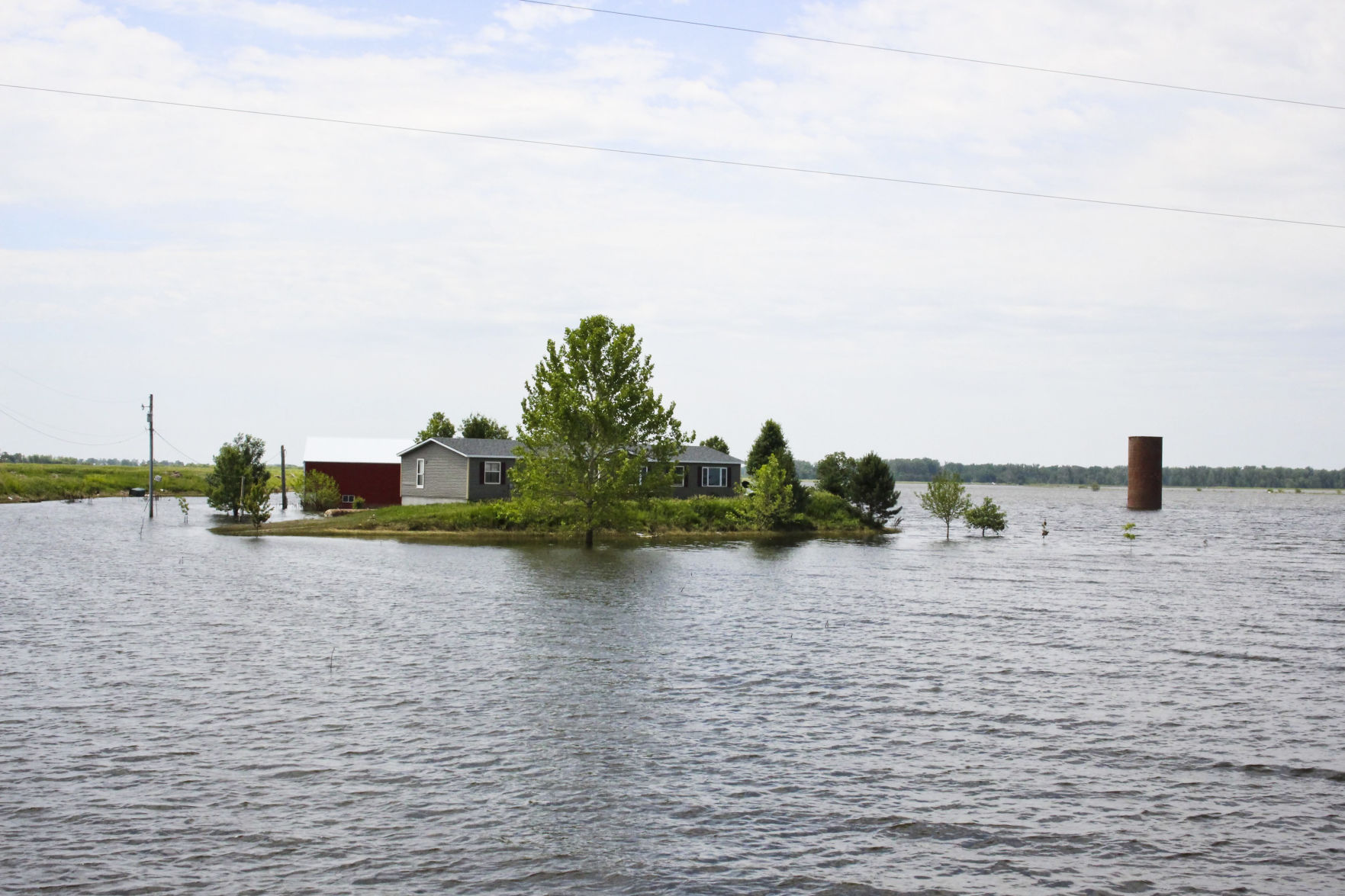 A home outside Pacific Junction, Iowa sits surrounded by flood waters